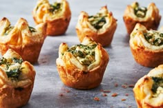 several mini quiches with spinach and cheese in them