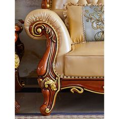 an ornate wooden chair with gold trimmings and decorative pillows on the arm rest