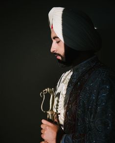 a man wearing a turban holding a golden object