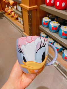 someone is holding up a mug that has been painted to look like donald ducky