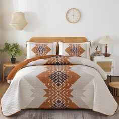 a bed with an orange and white bedspread in a bedroom next to a clock