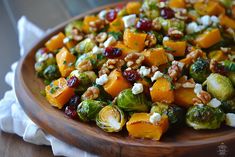 brussel sprouts, brussels sprouts, cranberries, walnuts and feta cheese on a wooden plate