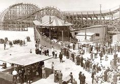 an old black and white photo of people in front of a roller coaster