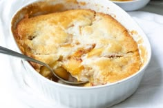 a close up of a casserole in a bowl with a spoon on the side