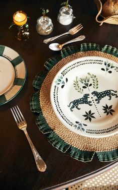 a table set with plates, silverware and utensils on top of it