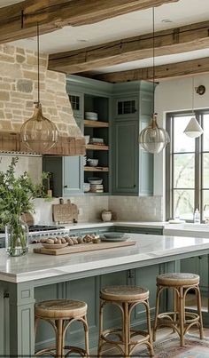 a kitchen with green cabinets and wooden stools in front of an island counter top