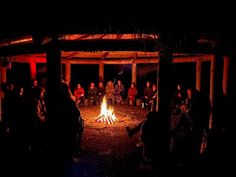 people sitting around a fire pit at night