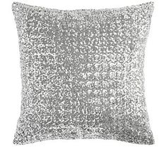 a silver pillow on a white background with lots of small glitters in the middle