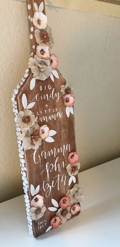 a wooden sign with flowers on it