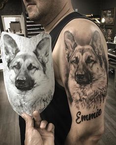 a man is holding up two pictures of dogs on his arm