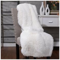 a white chair covered in a fluffy blanket