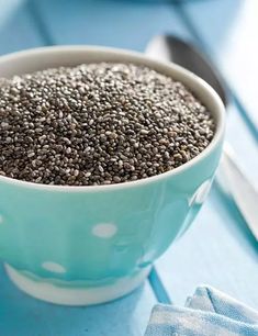 a bowl filled with chia seeds on top of a blue table