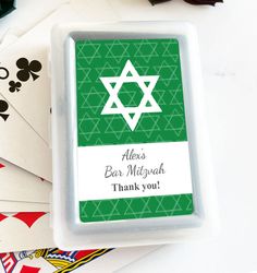 a green and white bar mitt with the star of david on it, surrounded by playing cards