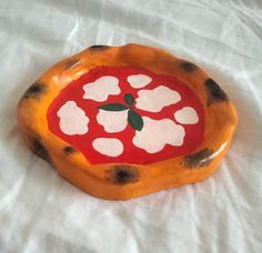 an orange and black plate with white dots on it sitting on a tablecloth covered surface