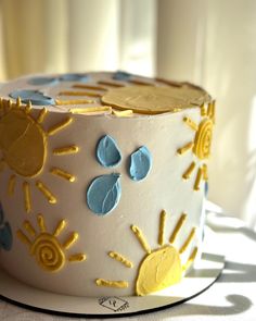 a white cake with yellow and blue frosting on it's side sitting on a table