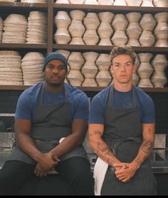 two men in aprons sitting next to each other