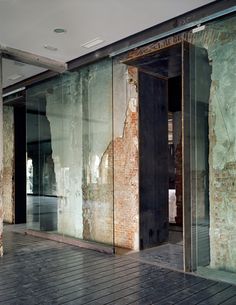 an empty room with glass doors and brick walls