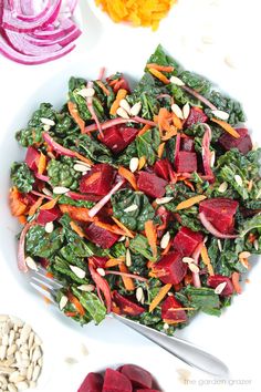 a salad with beets, carrots and almonds on a white platter