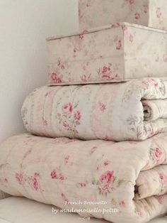 a stack of blankets sitting on top of a white shelf