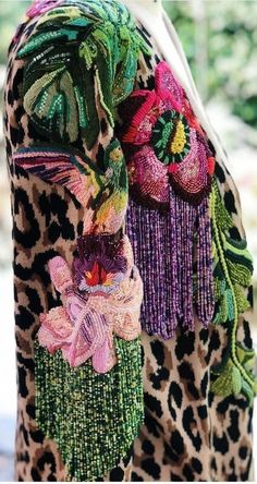 the back of a woman's jacket with animal print and flower decorations on it