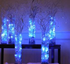 three vases filled with blue lights on top of a table