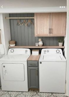 a washer and dryer sitting in a room next to each other with wooden cabinets