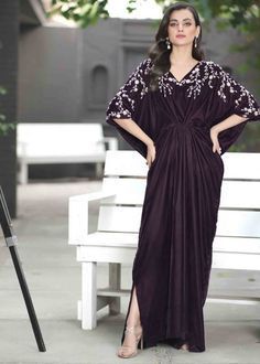 a woman standing next to a white bench wearing a purple dress and matching heels with her hands on her hips