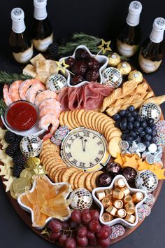 a platter filled with cheese, crackers, grapes and meats