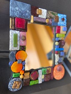 a mirror made out of colorful glass beads