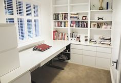 a white desk and bookshelves in a room