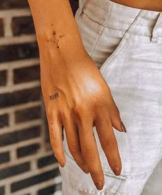 a woman's hand with a small tattoo on it