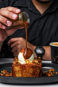 a man pouring syrup on top of a piece of cake