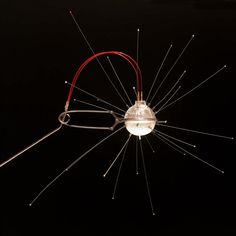 a light bulb with many wires attached to it's sides and an object in the middle