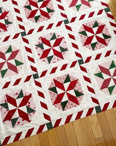 a red and green quilt on the floor