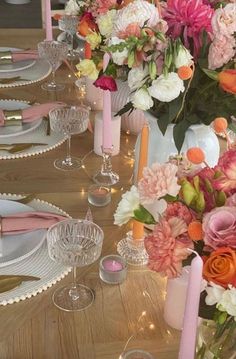 the table is set with pink and orange flowers