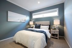 a bedroom with blue walls and white bedding