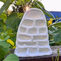 a white ice tray sitting on top of a wooden table next to sunflowers