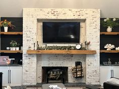 a living room with white brick fireplace and tv mounted on the wall above it's mantle