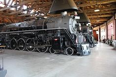 an old fashioned train is on display in a large room with exposed ceilings and beams