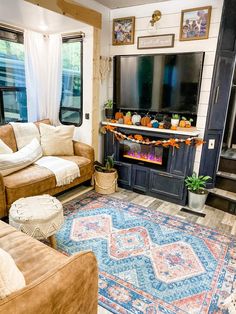 a living room filled with furniture and a flat screen tv mounted to a wall next to a fire place