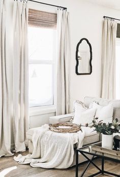 a living room filled with furniture and curtains