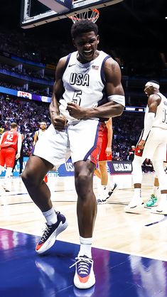 a basketball player is walking on the court with his hands in his pockets and smiling