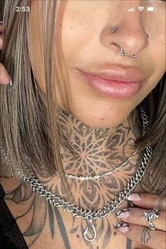 a woman with tattoos and piercings on her neck