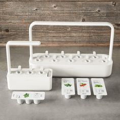 a set of four white plastic garden planters with six plants on each one side