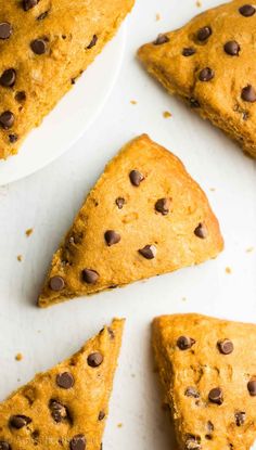 four pieces of chocolate chip scones on a white plate with one slice cut out