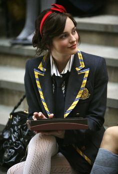 a woman is sitting on the steps with her hat in her hand and looking at something