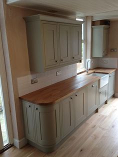 an empty kitchen with wooden floors and cabinets