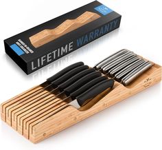 a wooden cutting board with knifes and knives in it next to a box that says lifetime warrant