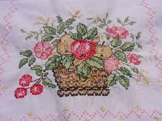 a close up of a flower pot on a table cloth with pink and red flowers