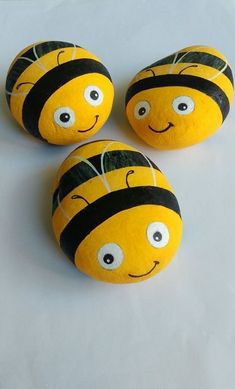 three yellow and black painted rocks with eyes